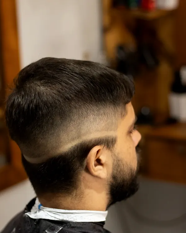 Mid fade with a shaved part line, seen from behind