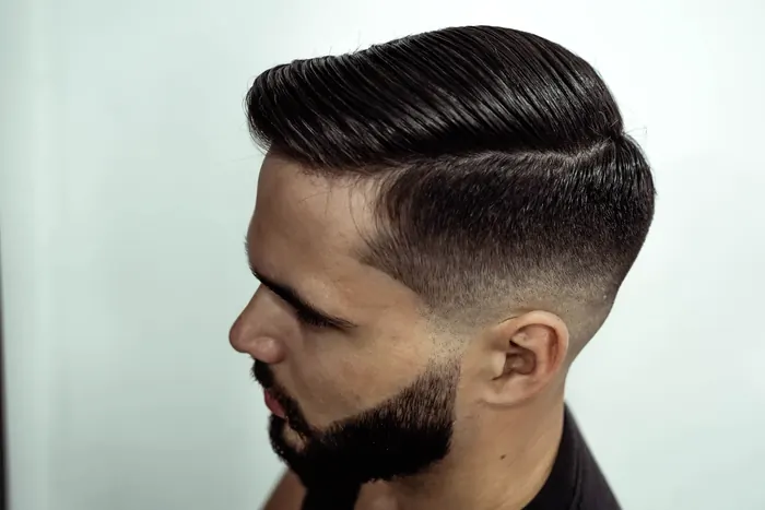 Slicked side part with a skin fade and a trimmed beard